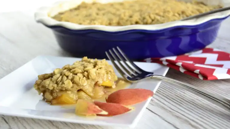 Butterscotch Peach Crisp with Fresh Peaches on a white plate.