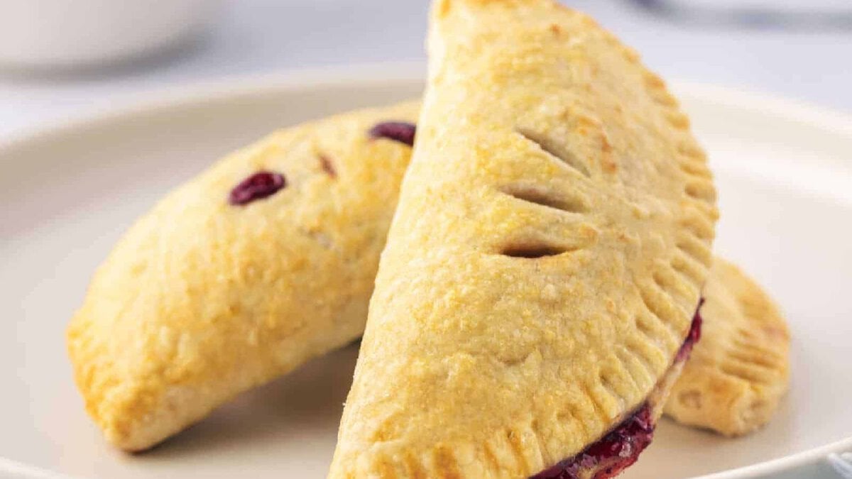 Two cherry handpies on a white plate.