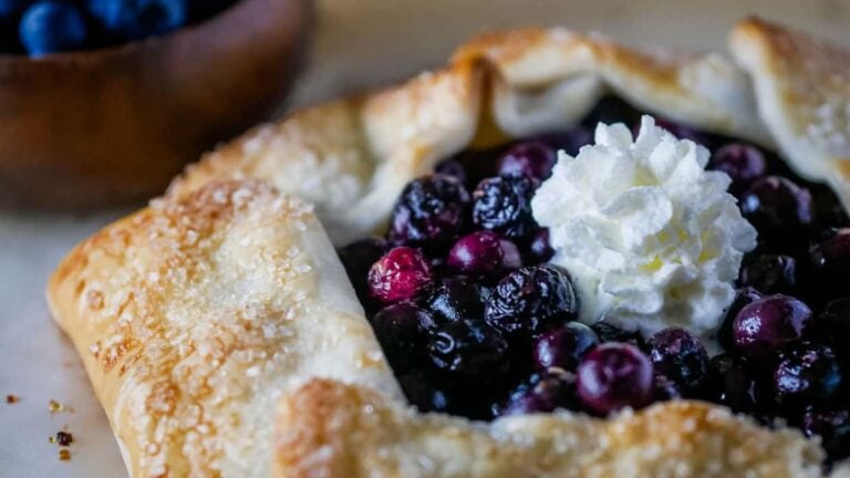 Blueberry galette topped with whipped cream.