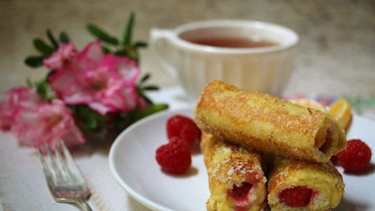 A white platter with raspberry French toast rolls.