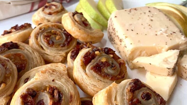 Pear and cranberry pinwheels on a white board.