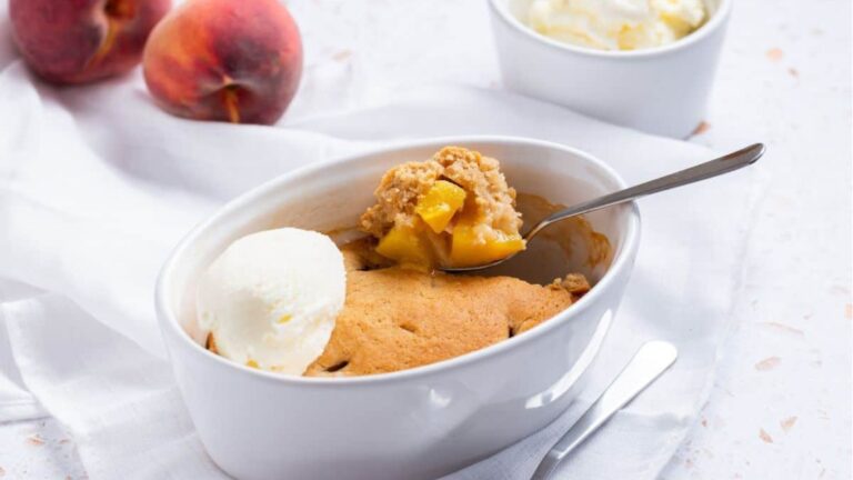 Peach cobbler with ice cream and peaches.