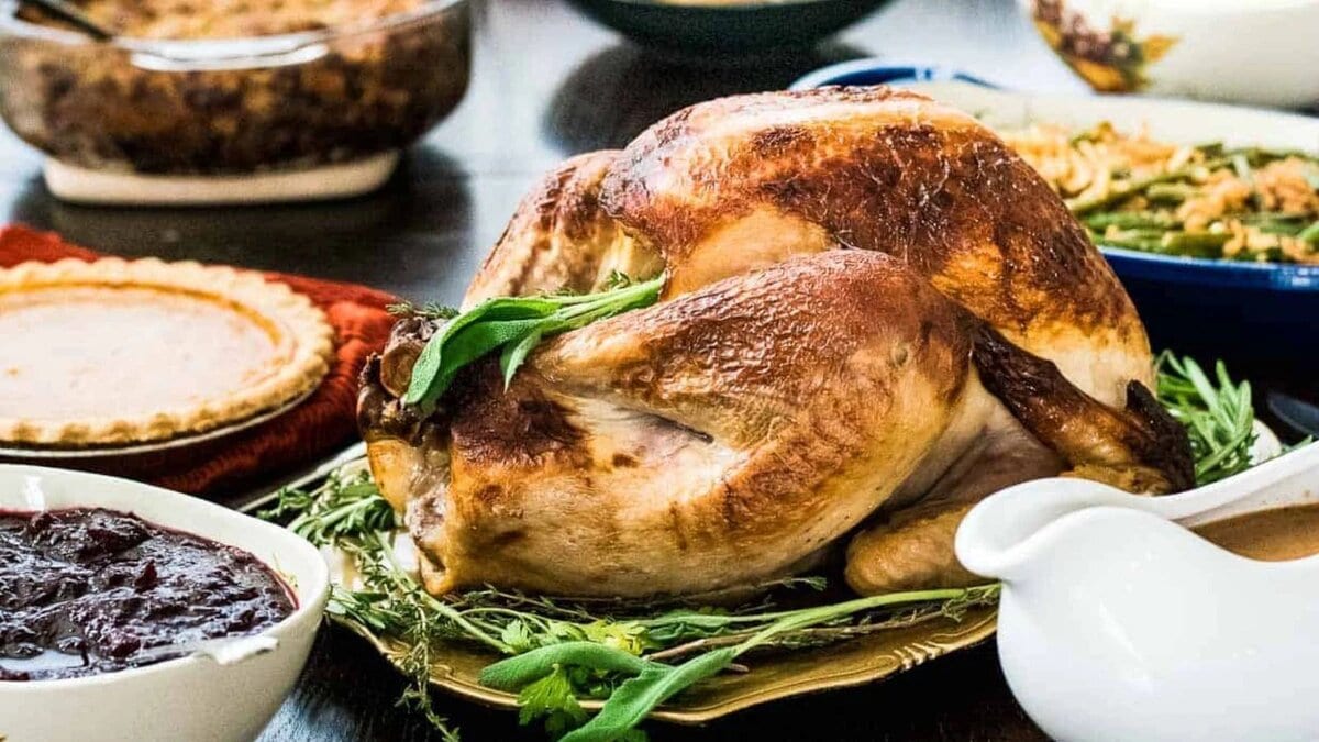 A buttermilk brined roasted surrounded by festive holiday side dishes.