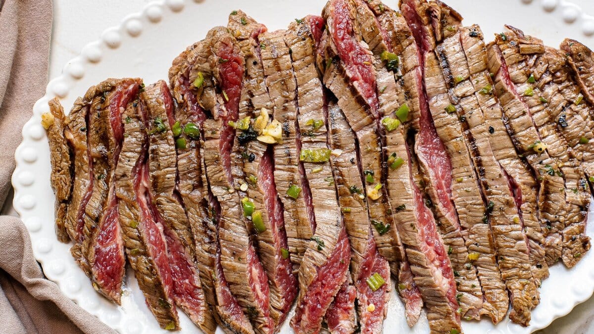 Marinated grilled meat, sliced and on a platter.