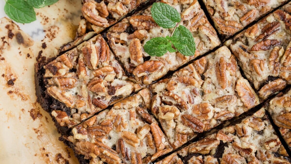 Brownies with pecans and mint on a baking sheet.