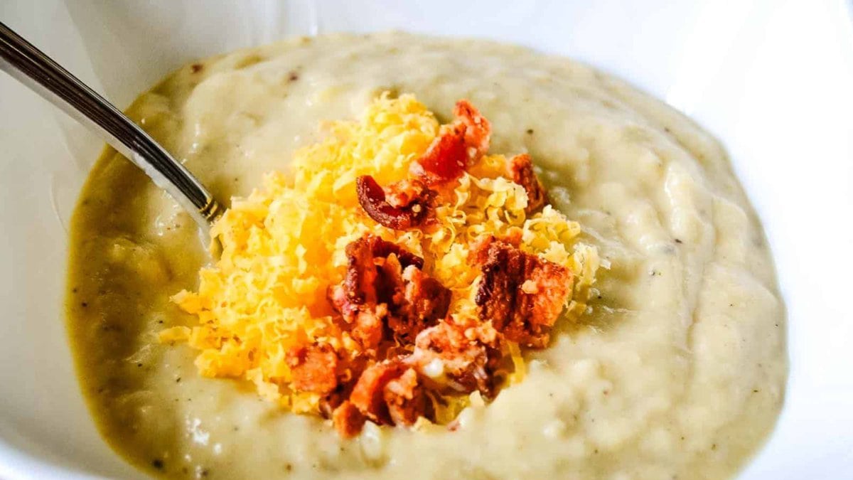 A bowl of loaded parsnip potato soup topped with bacon and cheddar cheese.