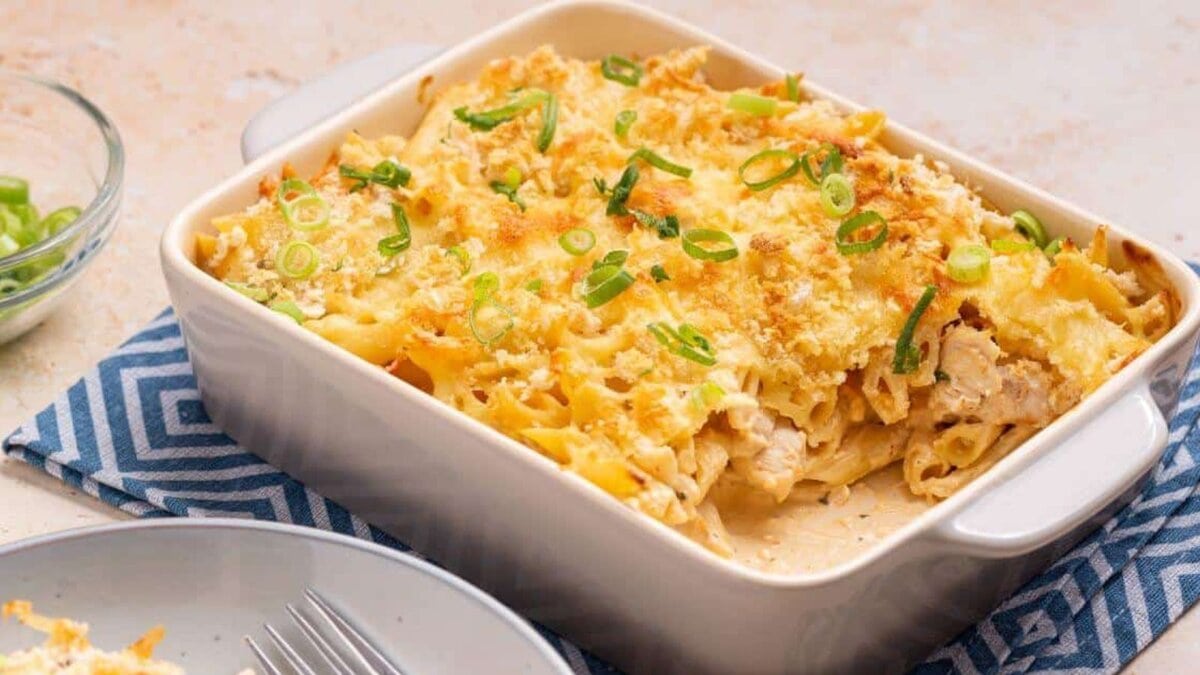 Serving of buffalo chicken pasta bake with casserole dish.