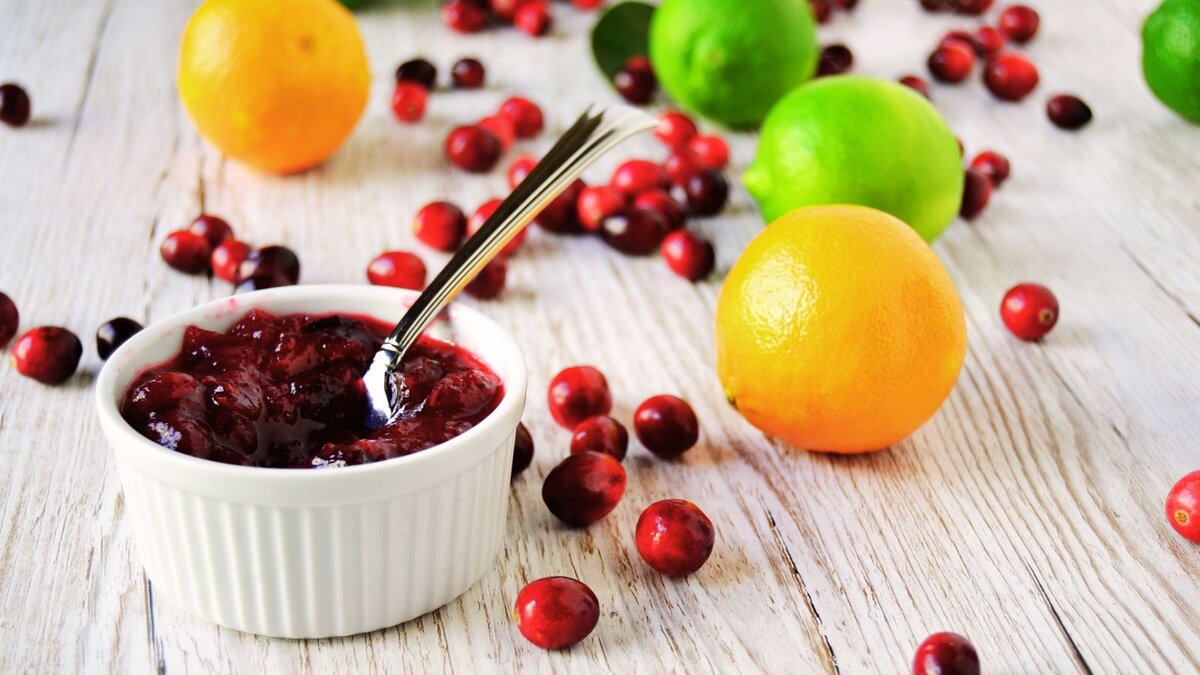 A bowl of cranberry sauce with cranberries, oranges and lemons.
