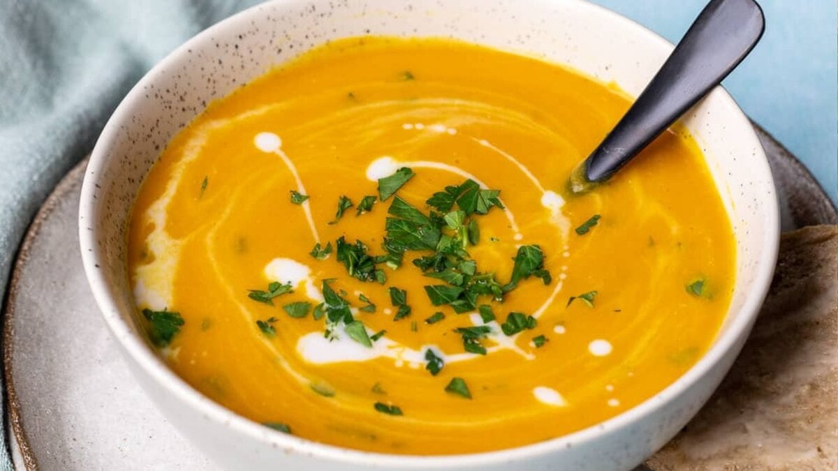 Spiced carrot and lentil soup with a creamy texture served in a bowl.