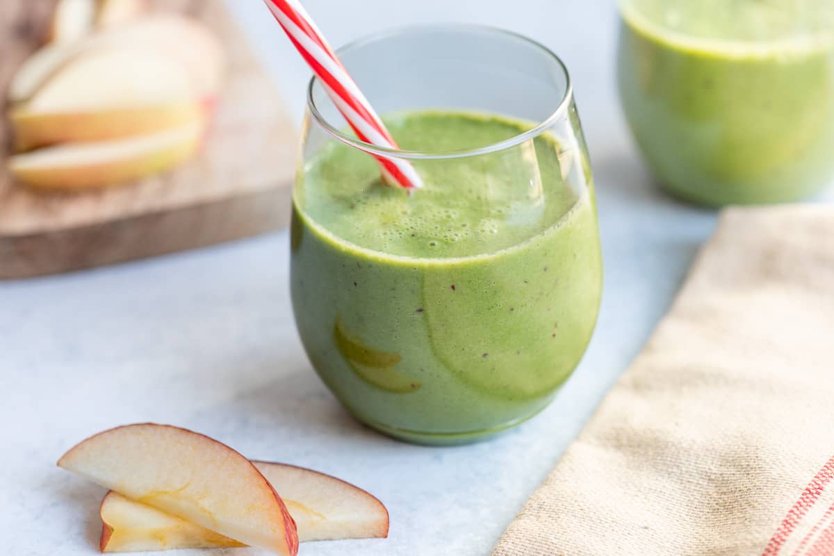 Glass of green apple spinach smoothie with a creamy texture.