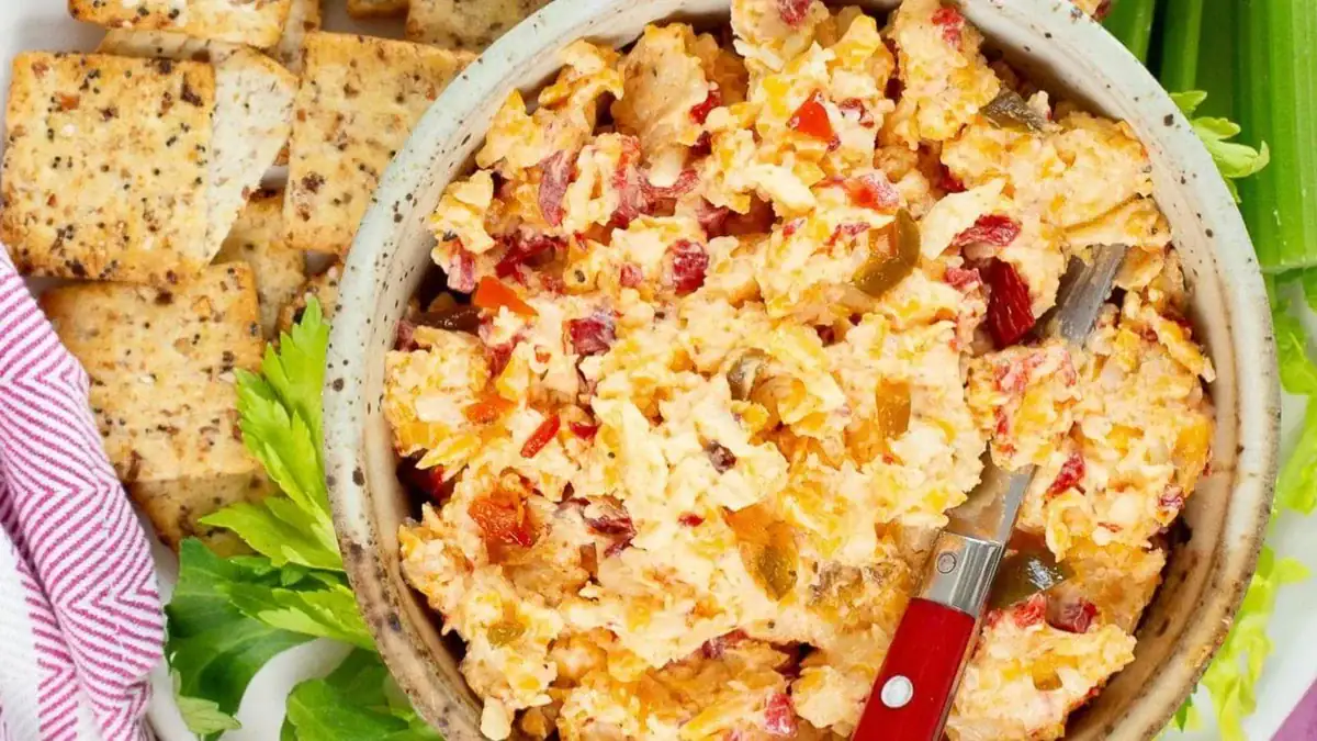 A bowl of spicy pimento cheese dip with crackers on the side.