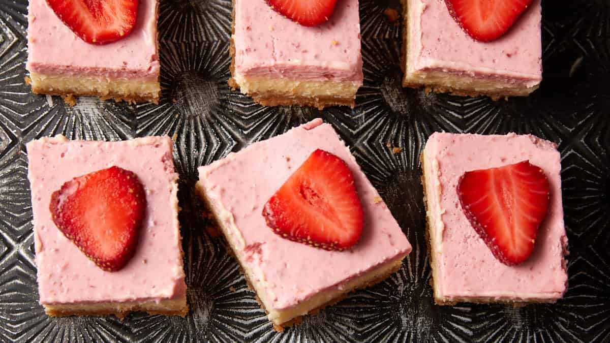 Strawberry cheesecake bars layered with creamy filling and fresh strawberries.